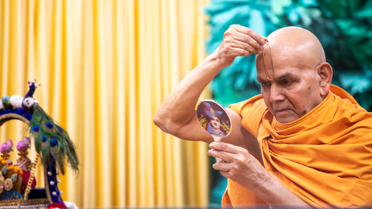 Swamishri applies a tilak on his forehead