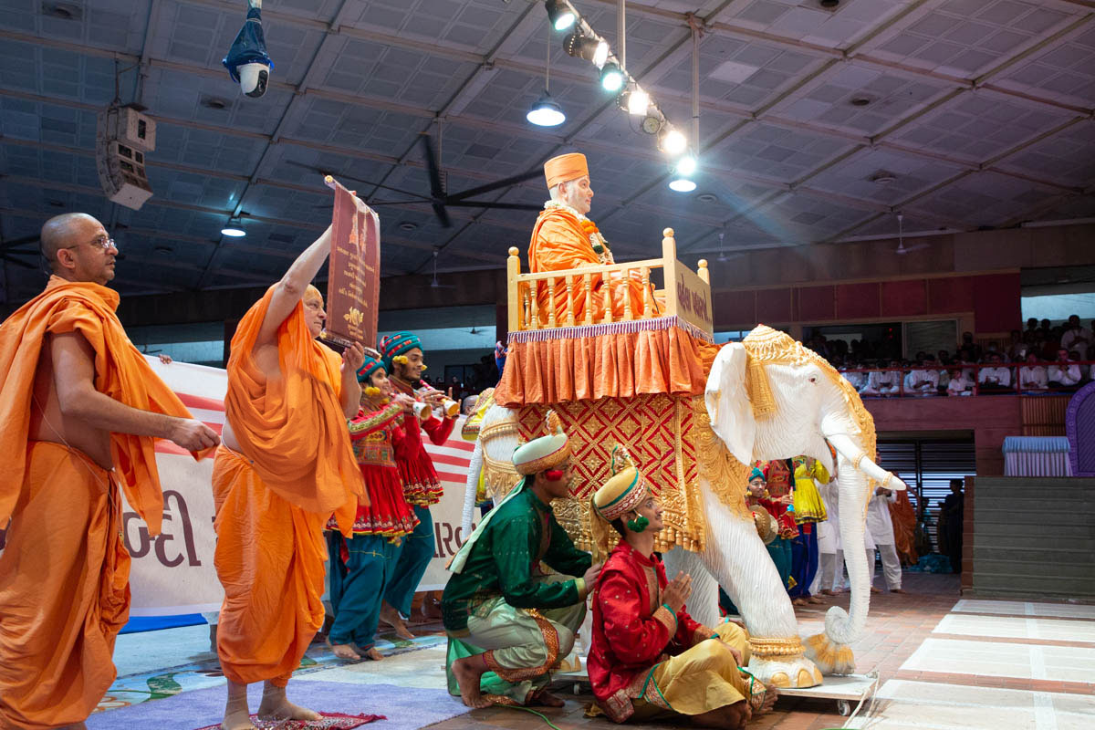 Pujya Ishwarcharan Swami presents an invitation card to Swamishri for the Pramukh Swami Maharaj Centenary Celebrations