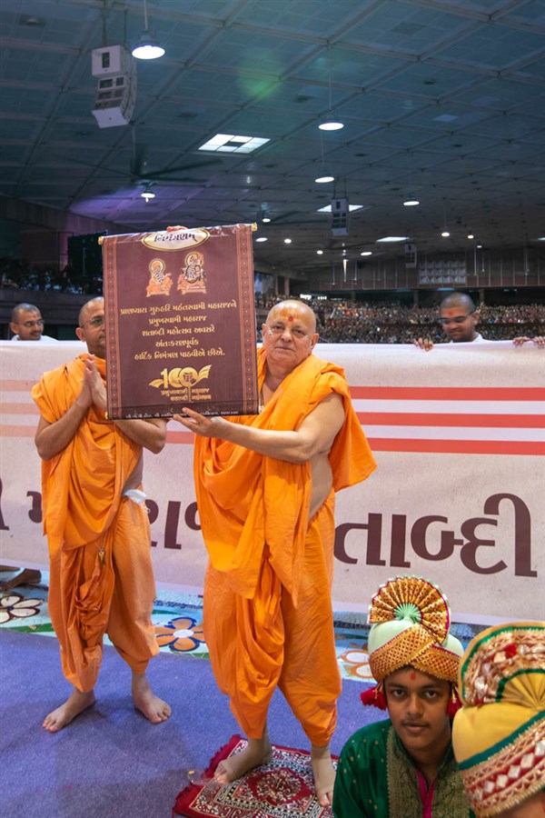 Pujya Ishwarcharan Swami presents an invitation card