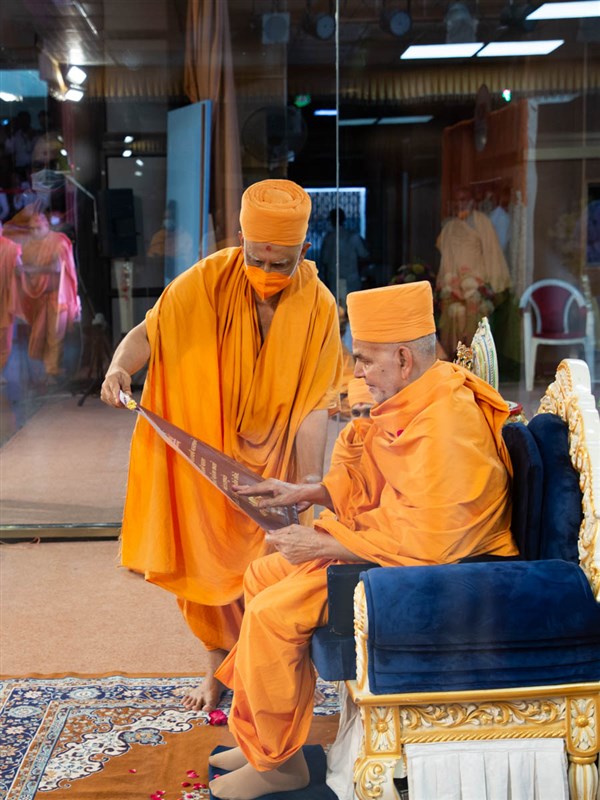 Swamishri sanctifies an invitation card
