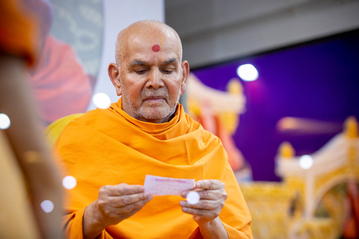 Swamishri reads a prayer from a devotee