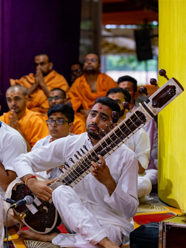  A youth plays the sitar in Swamishri's daily puja