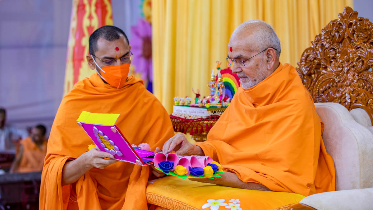 Swamishri sanctifies an invitation card