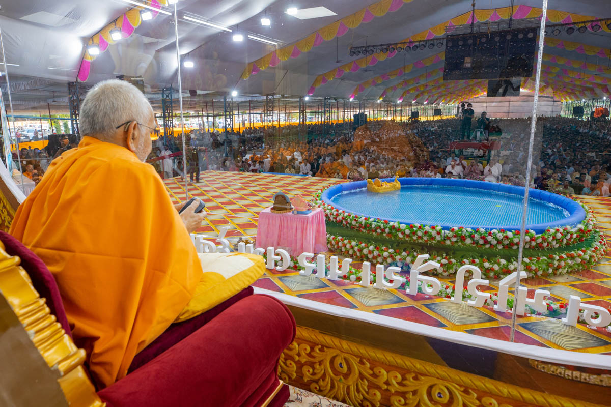 Swamishri maneuvers the boat by remote control