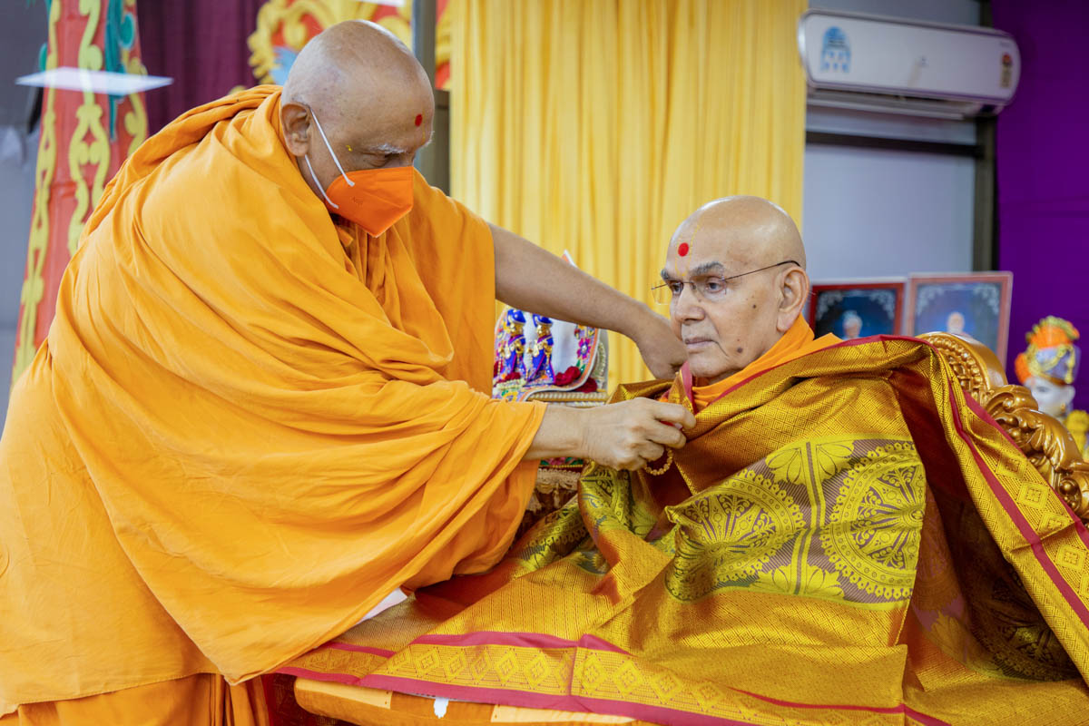 Atmaswarup Swami honors Swamishri with a shawl