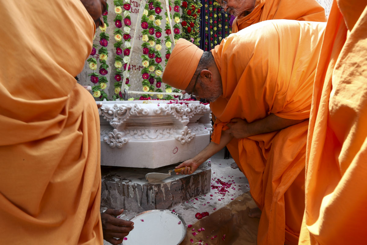 Bhadresh Swami pours cement mixture on the pillar
