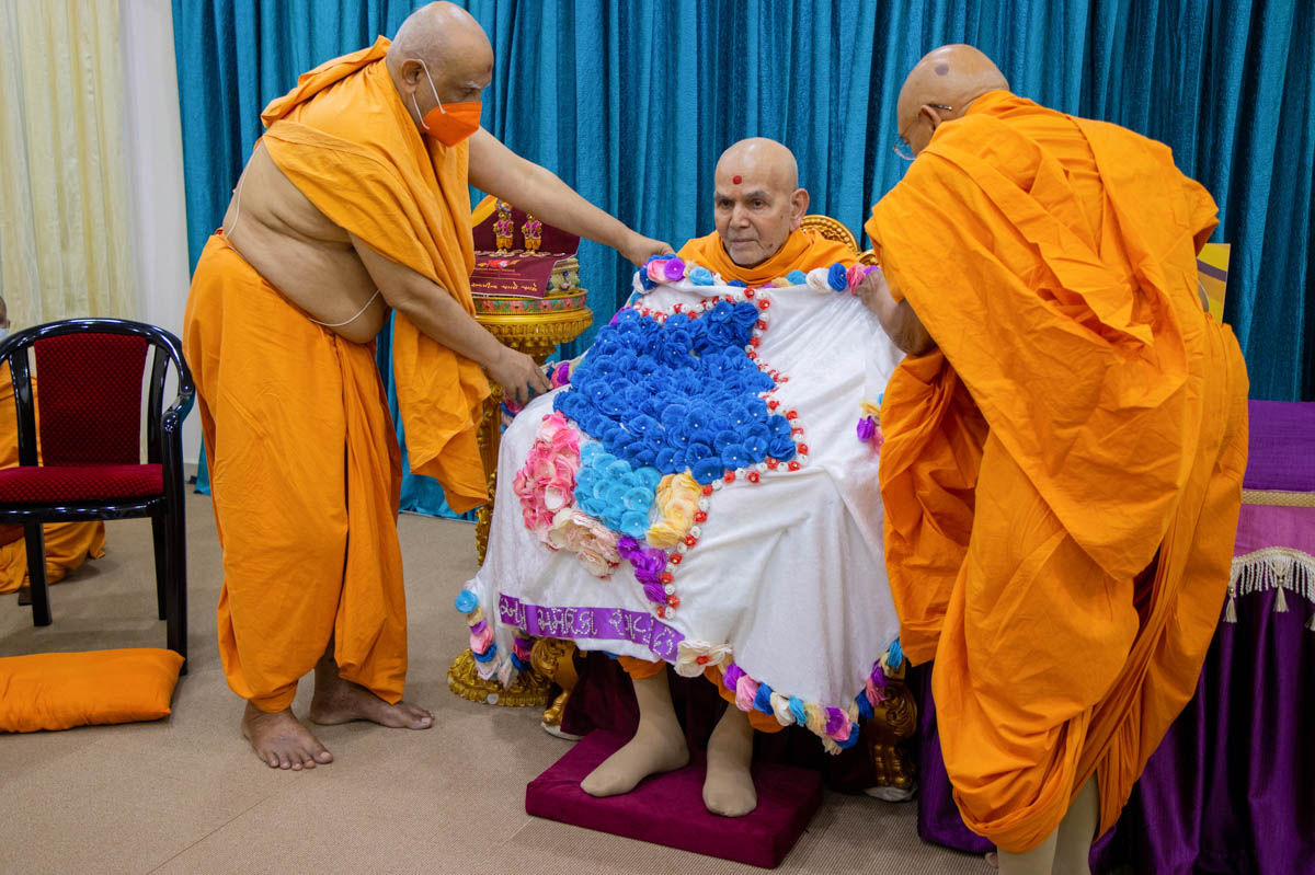Pujya Tyagvallabh Swami and Atmaswarup Swami honor Swamishri with a shawl