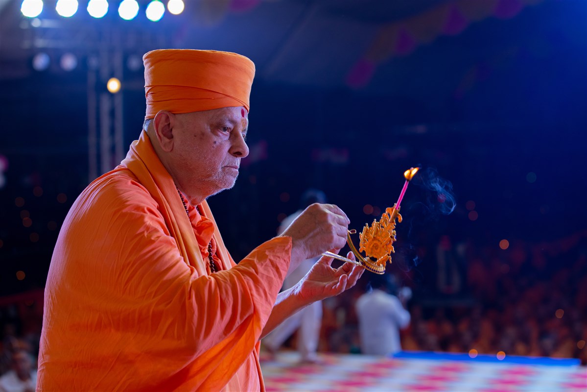 Pujya Ishwarcharan Swami performs the arti