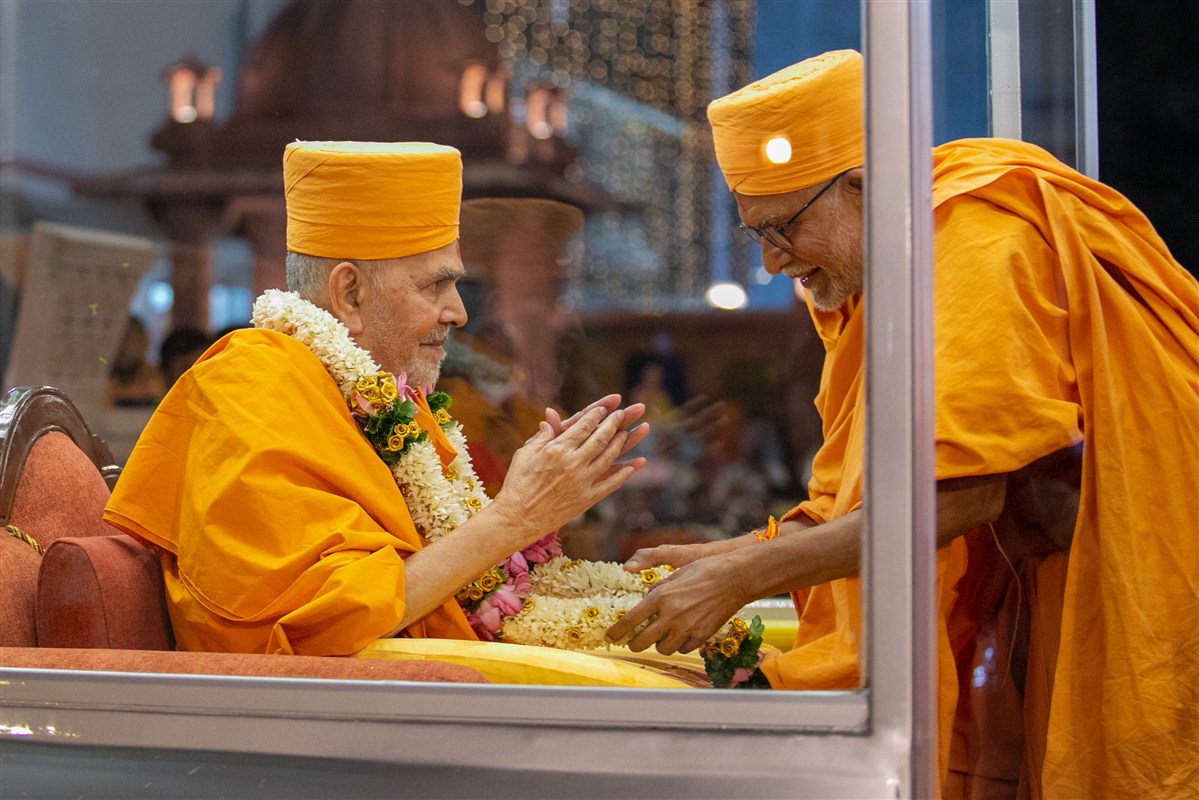 Pujya Bhaktipriya Swami (Kothari Swami) welcomes Swamishri with a garland 