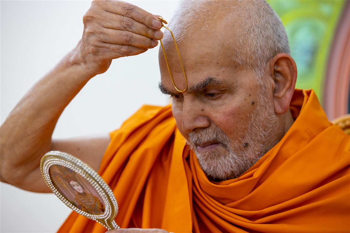 Param Pujya Mahant Swami Maharaj Swamishri applies a tilak on his forehead