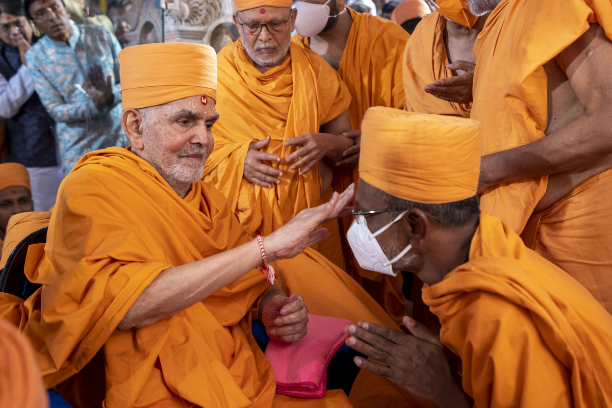 Swamishri applies a chandlo to Mahavrat swami