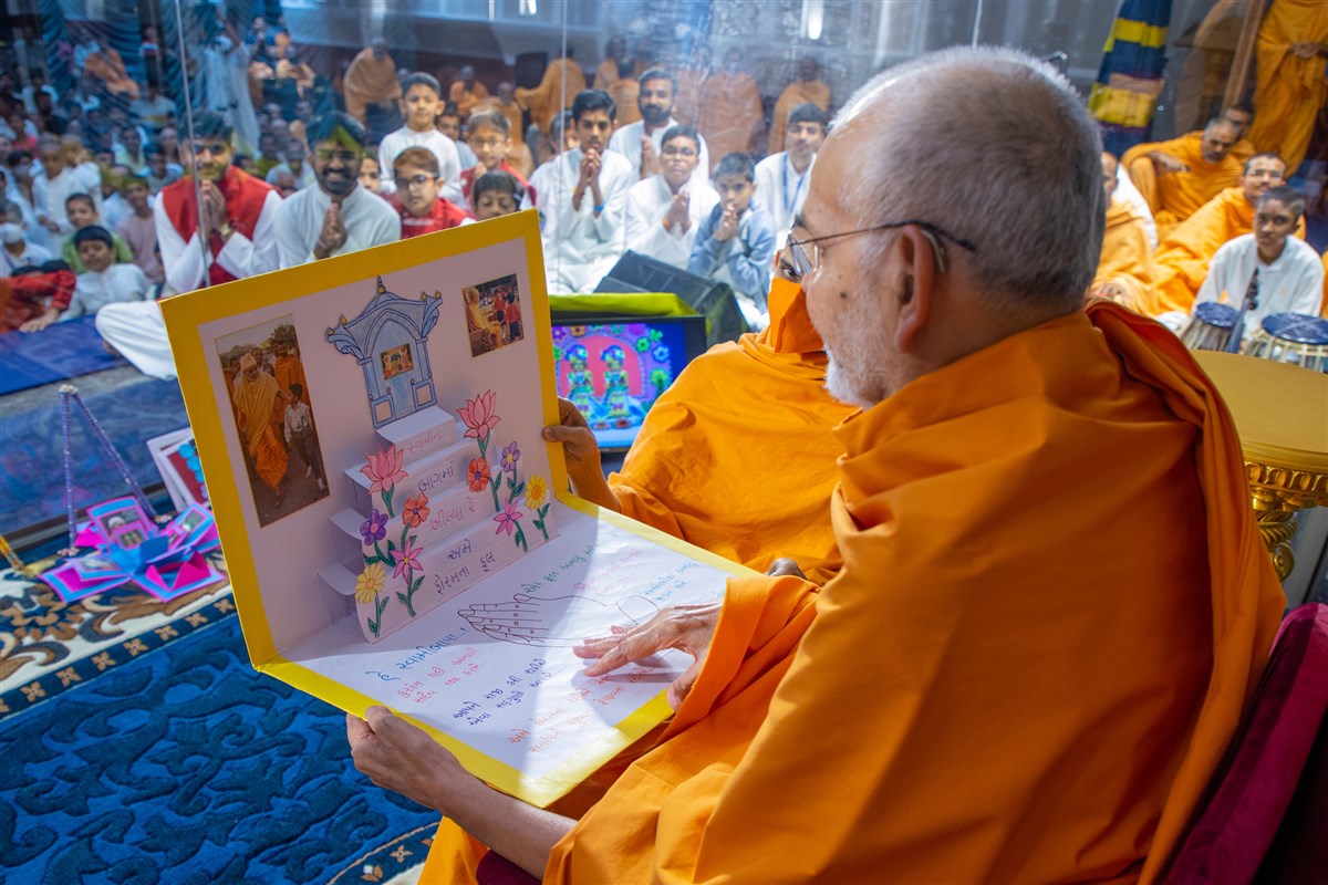 Swamishri reads the invitation card