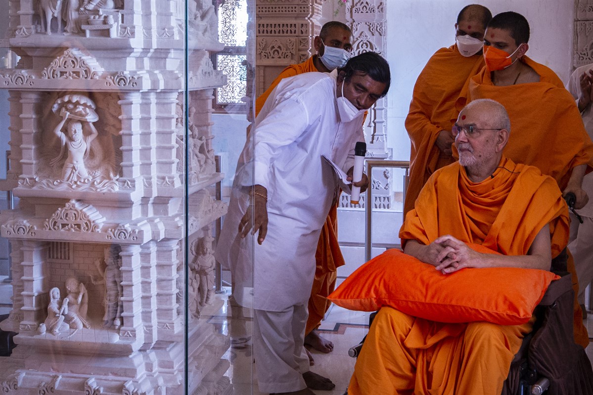 Swamishri observes the carvings on a pillar