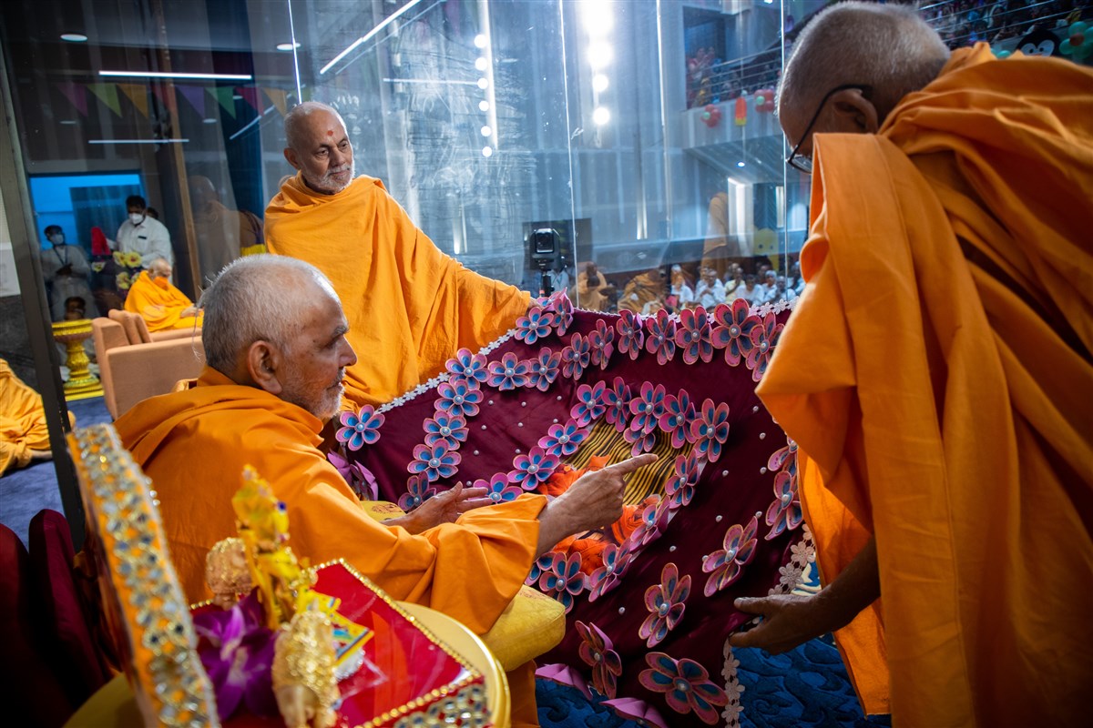 Swamishri observe a shawl