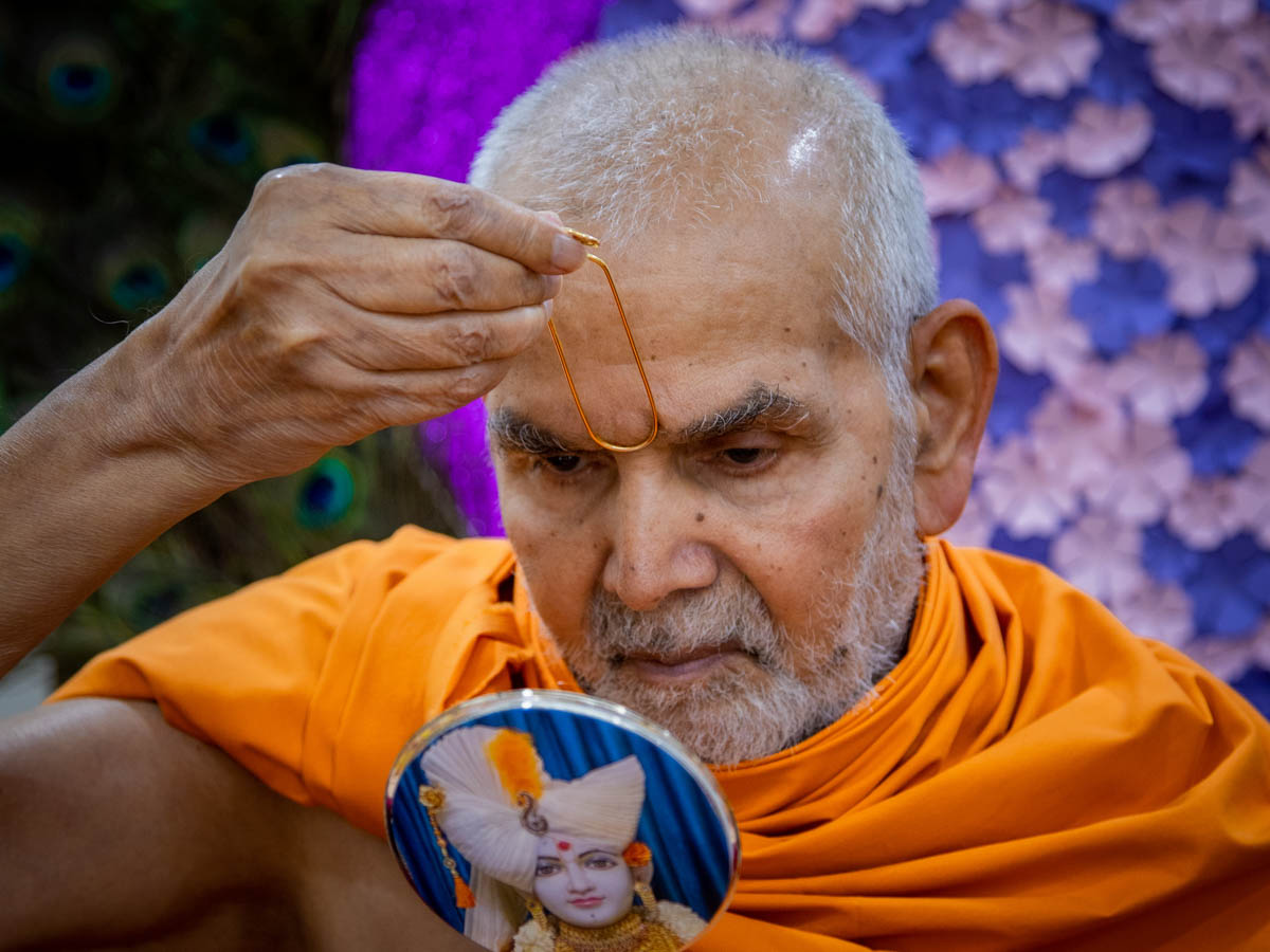 Swamishri applies a tilak on his forehead 