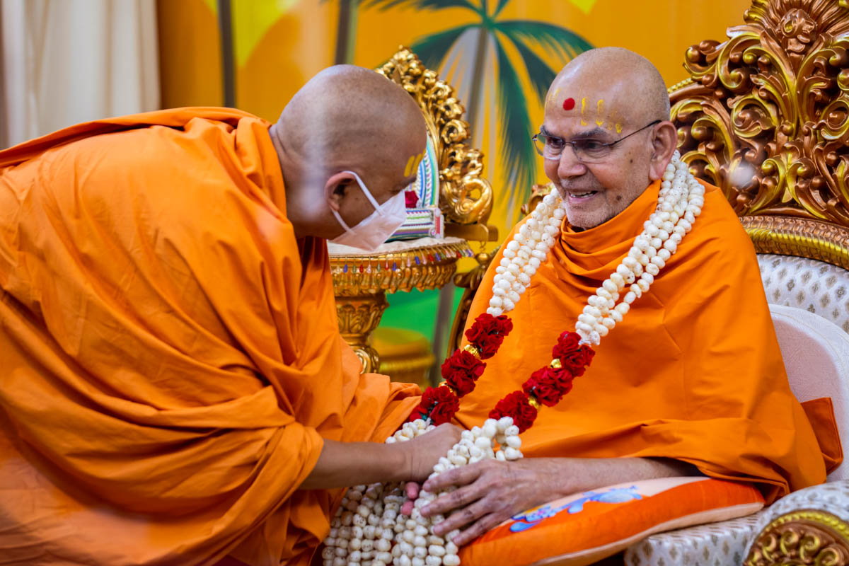 Brahmavihari Swami honors Swamishri with a garland