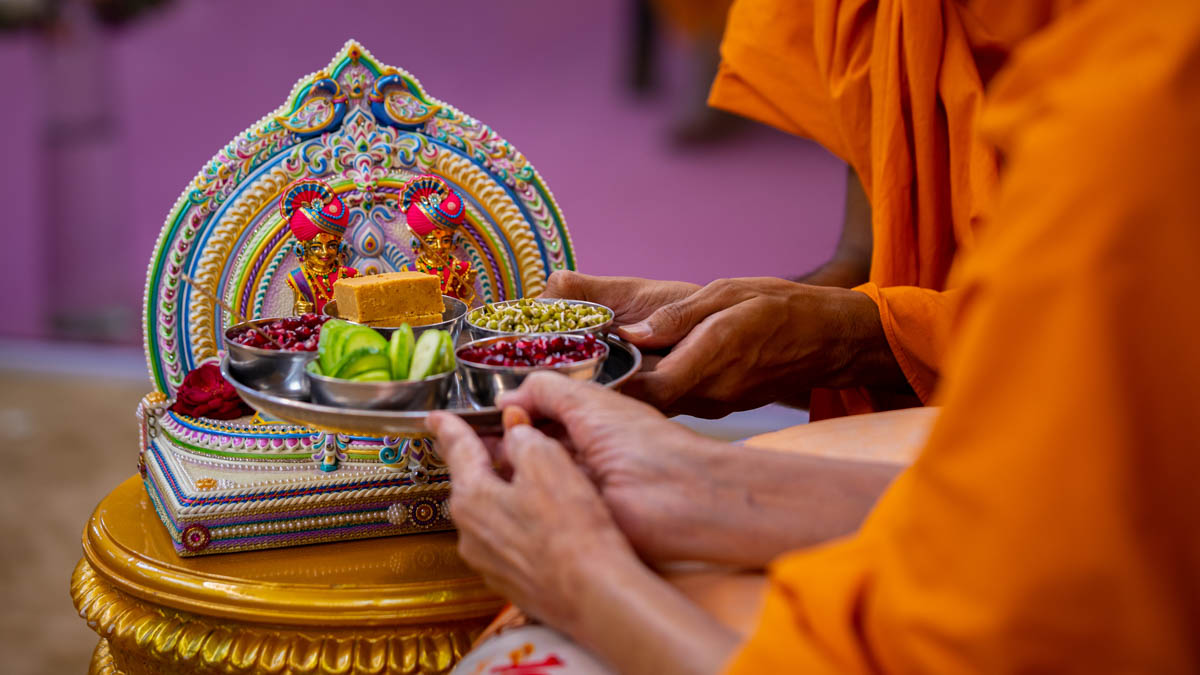 Swamishri offers thal to Shri Harikrishna Maharaj and Shri Gunatitanand Swami to celebrate the symbolic Jal Jhilani festival