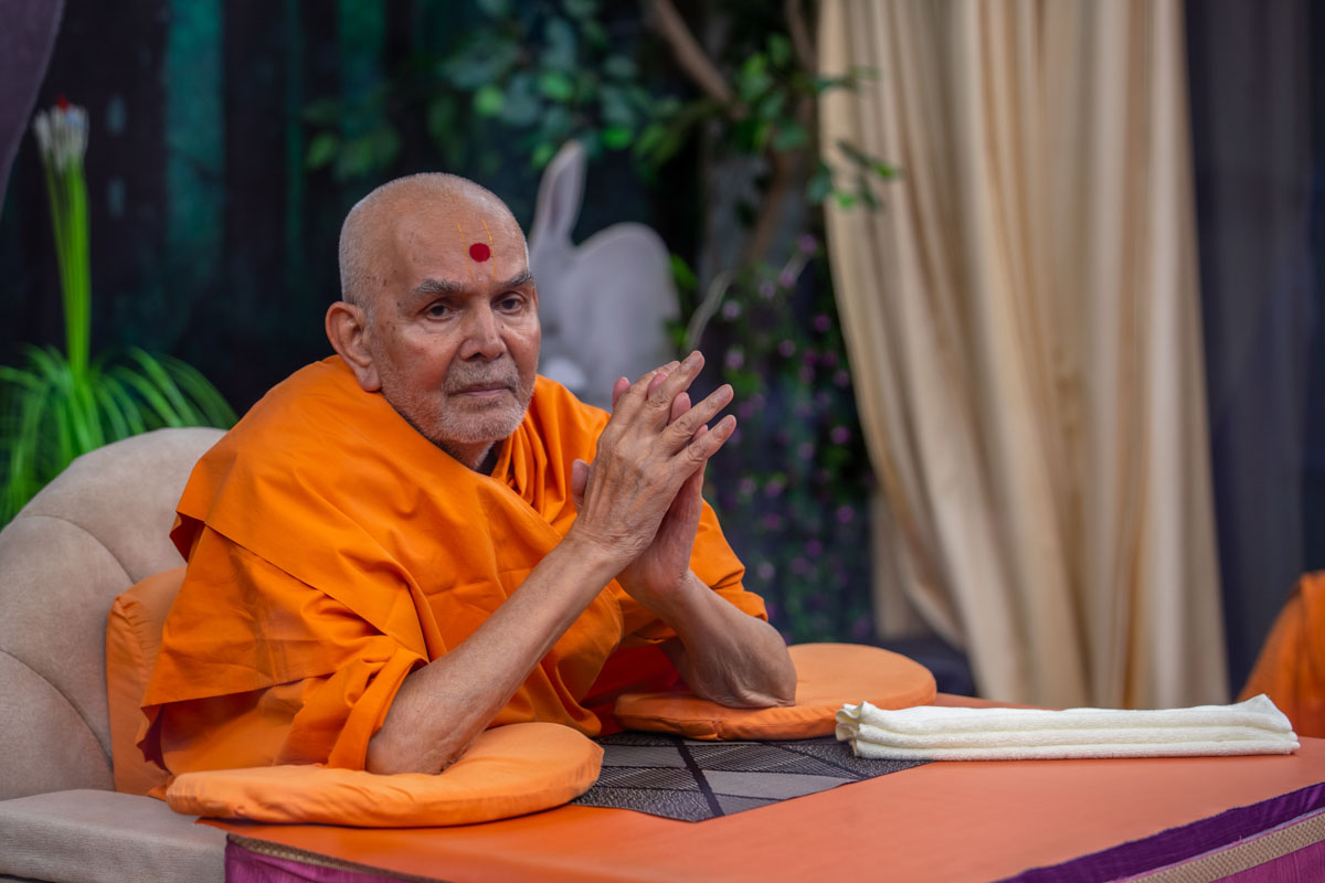 Swamishri greets volunteers with folded hands in the evening
