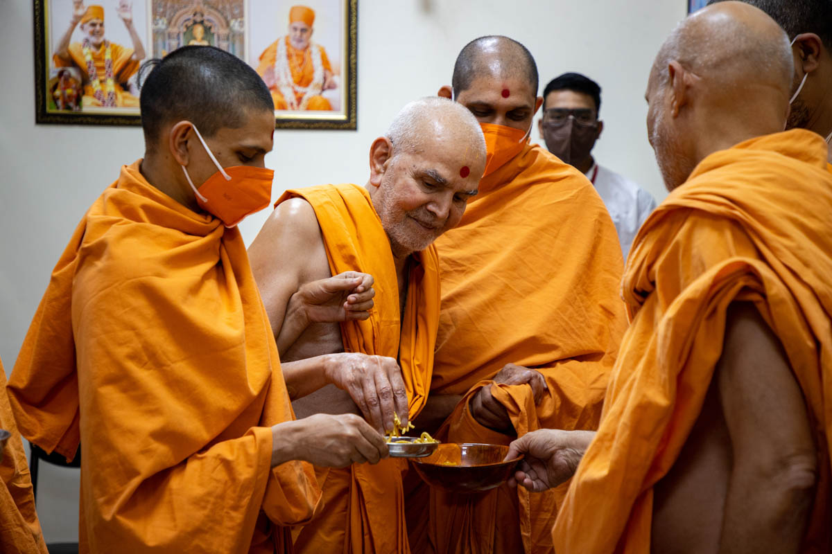 Swamishri gives prasad to Pujya Viveksagar Swami