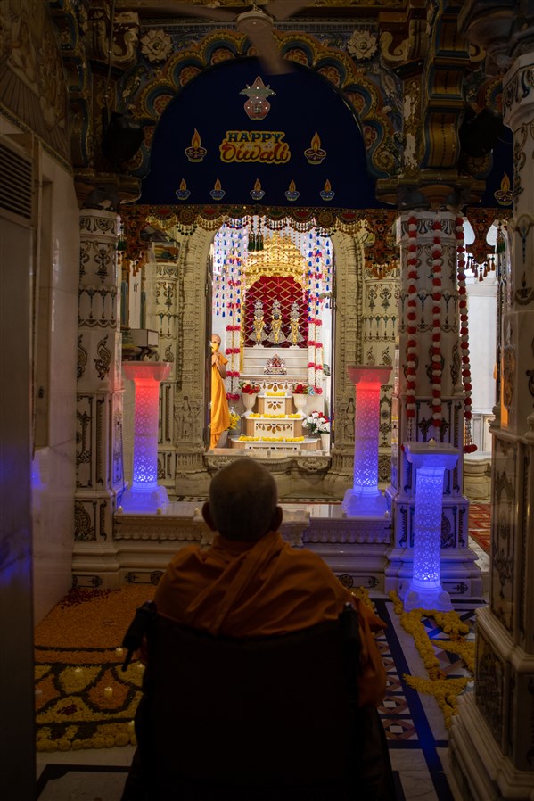 Swamishri engrossed in darshan of Bhagwan Swaminarayan, Aksharbrahma Gunatitanand Swami and Shri Gopalanand Swami