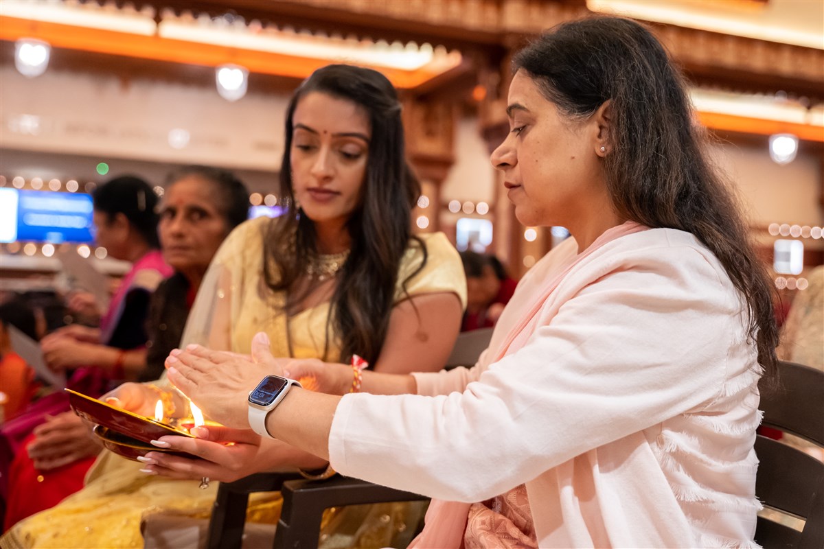During the Chopda Pujan tradition, a devotee receives the aura of the arti (lighted wick).