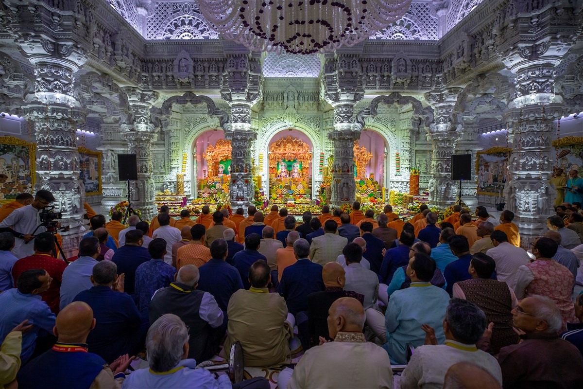 Devotees perform darshan of the sacred images of God and the Annakut.
