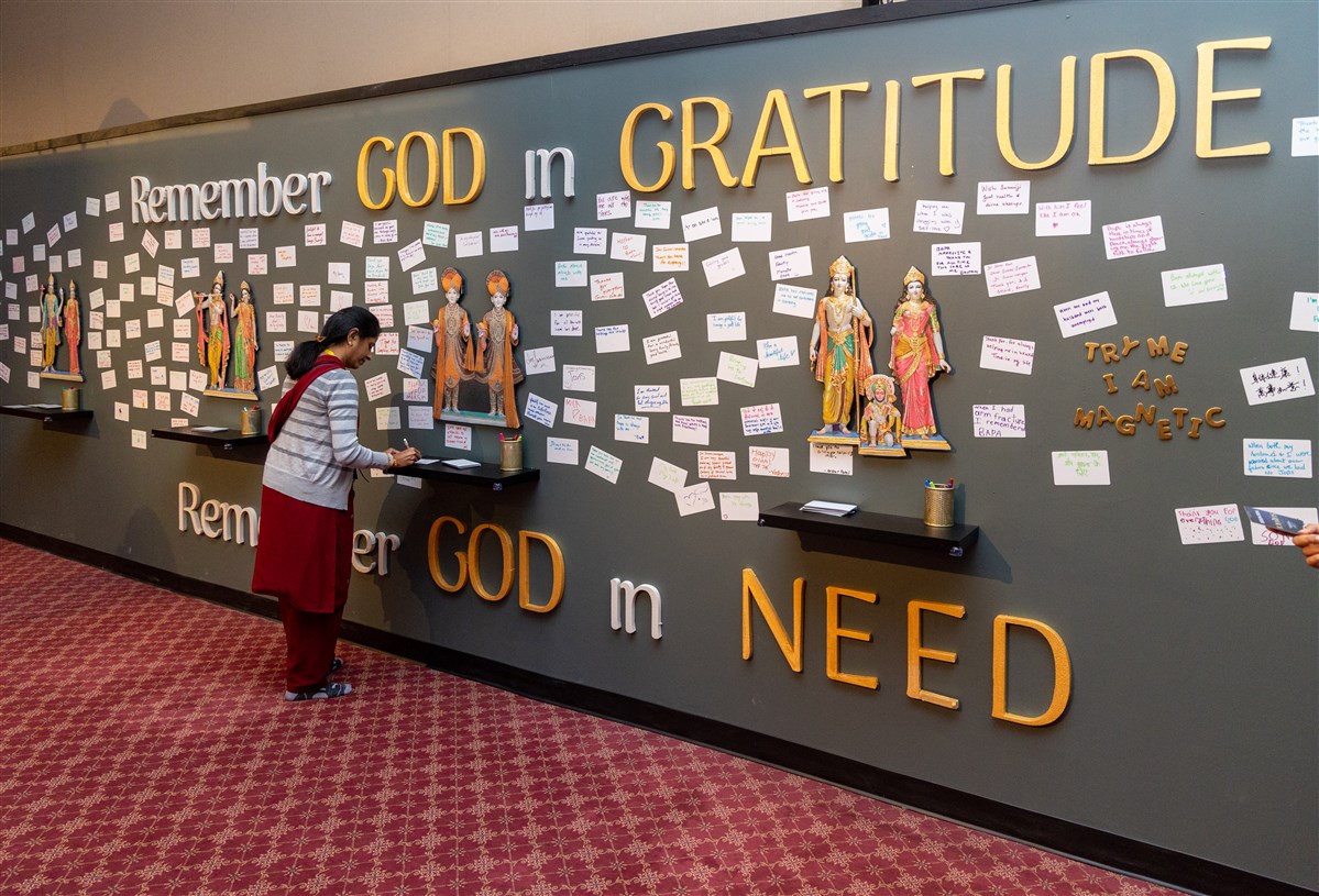 A visitor writes a 'thank you' note to God in the Century of Service exhibition.