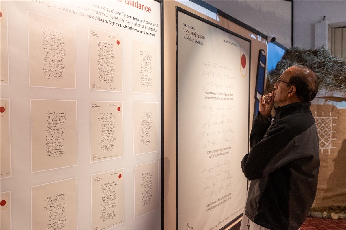 A visitor attentively reads a panel in the Century of Service exhibition which presents a letter written by Pramukh Swami Maharaj. The letter contains detailed funeral arrangements for a devotee. This is but one example of the genuine care Swamiji had for others.