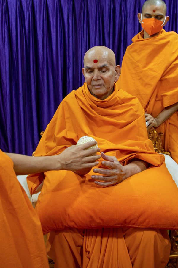 Swamishri sanctifies a decorative ball