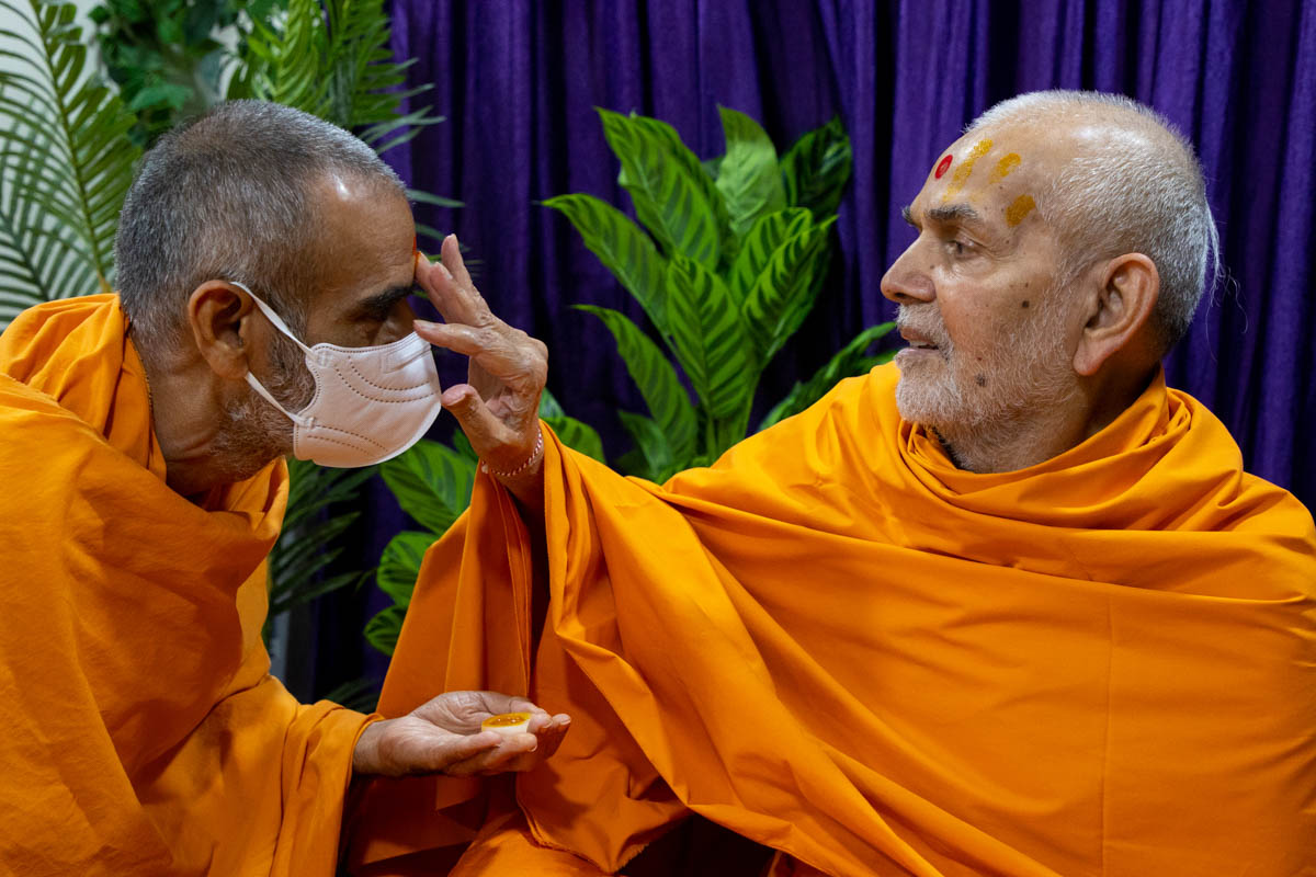 Swamishri applies a chandlo to Anandswarup Swami