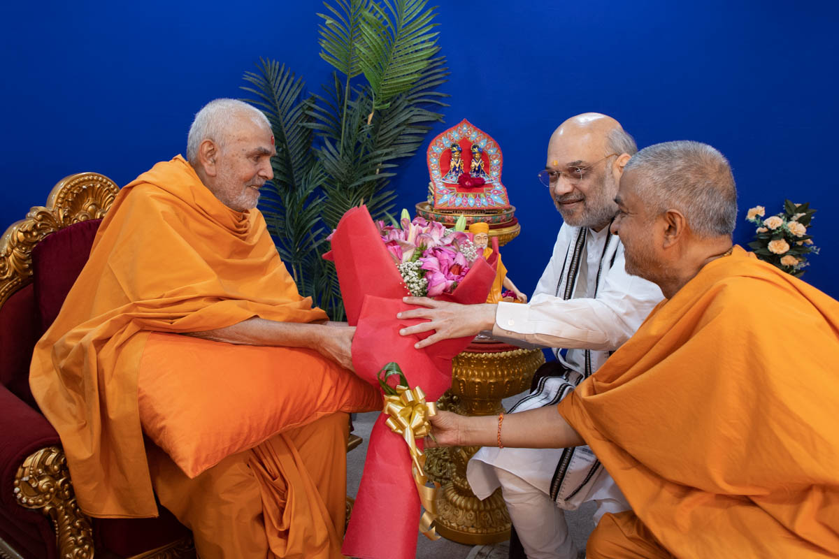 HH Mahant Swami Maharaj presents flower bouquet to Shri Amit Shah