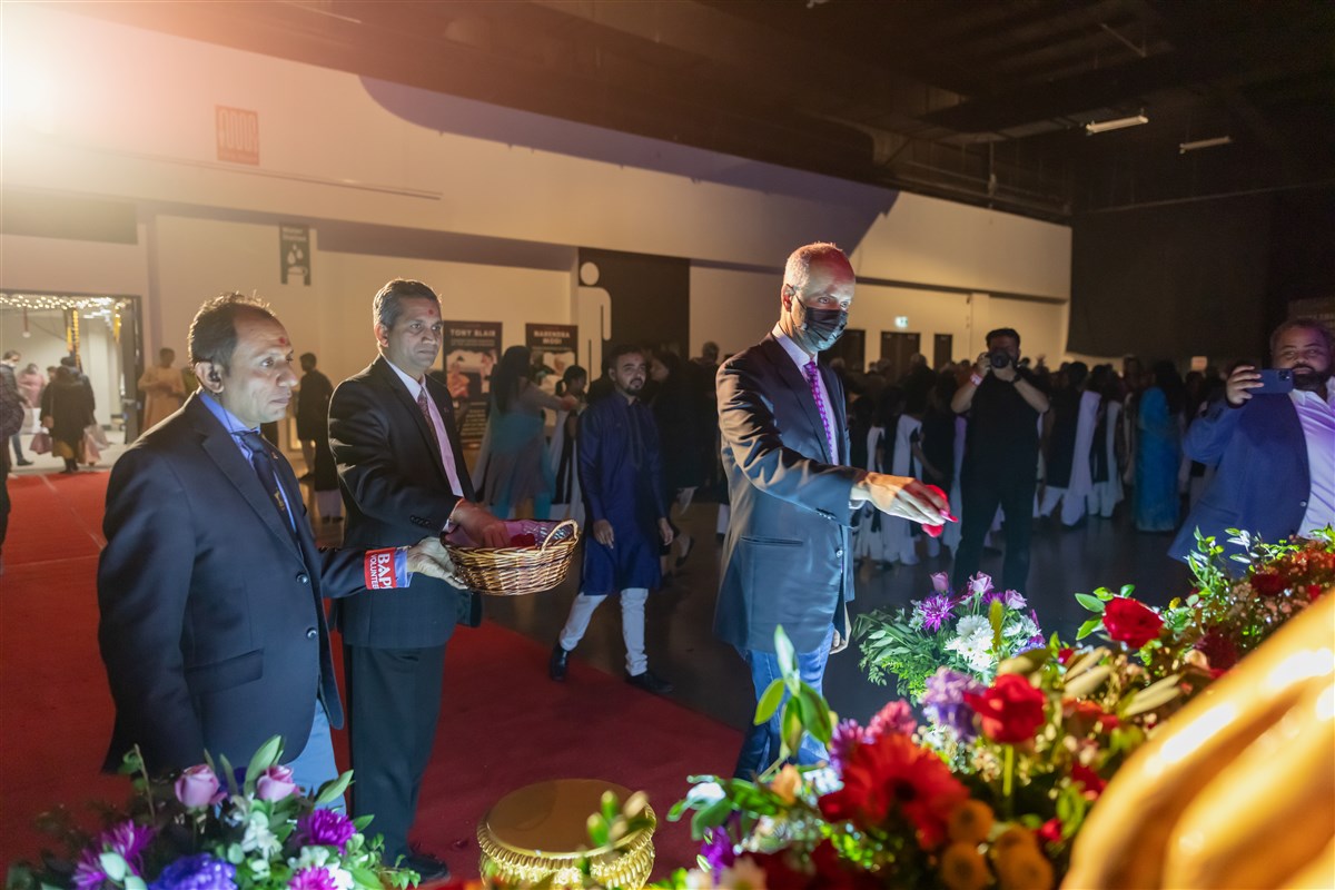 Hon. Ahmed Hussen, Minister of Housing And Diversity And Inclusion, offers flowers to Pramukh Swami Maharaj