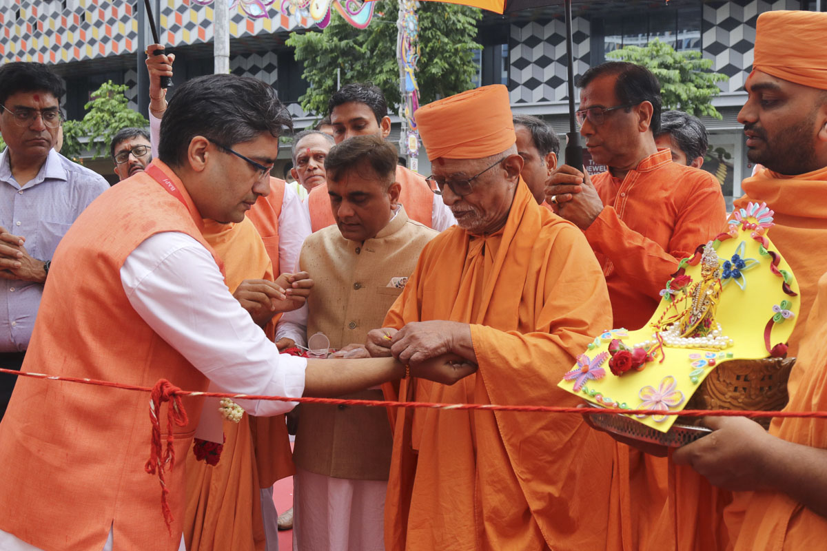 Pujya Doctor Swami ties a nadachhadi to a devotee