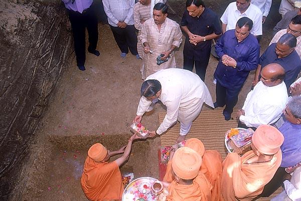 During the foundation-stone laying ceremony for the hostel of Hiramani School, on behalf of Swamishri, Pujya Ishwarcharan Swami performs the rituals 