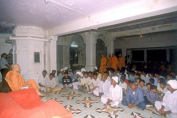 While Swamishri performs pradakshina, the local devotees listen to a discourse