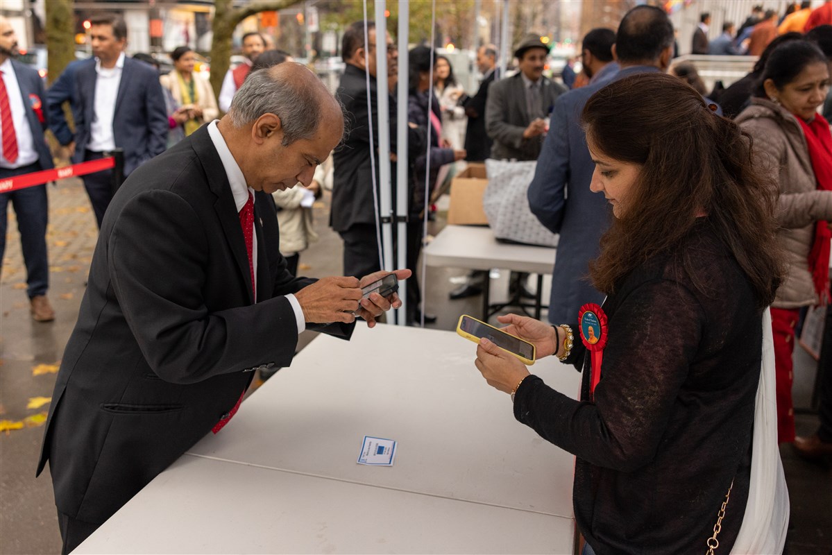 A BAPS volunteer assists with check-in outside UN Headquarters.