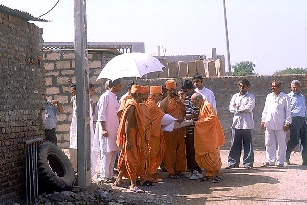 Swamishri visits and discusses the land around the BAPS mandir for the development project of Aksharbrahma Gunatitanand Swami's birth place