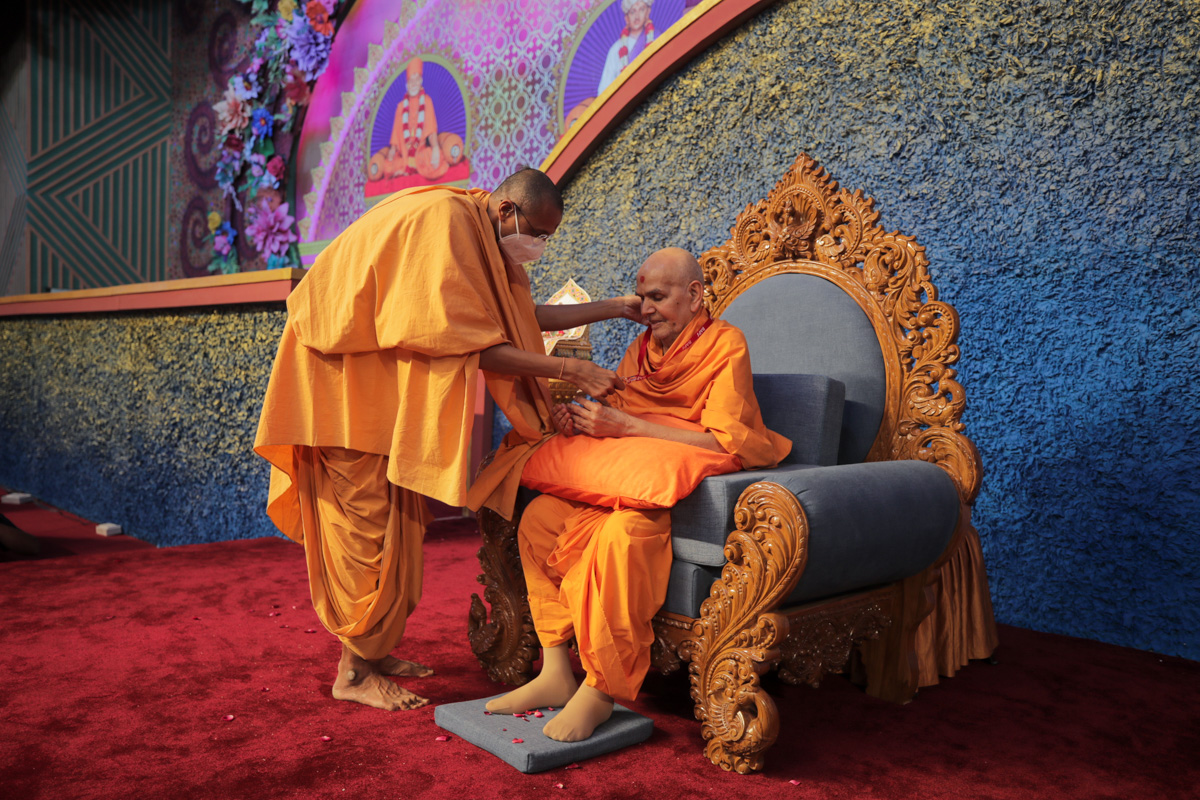 Vivekmuni Swami offers a volunteer ID card to Swamishri