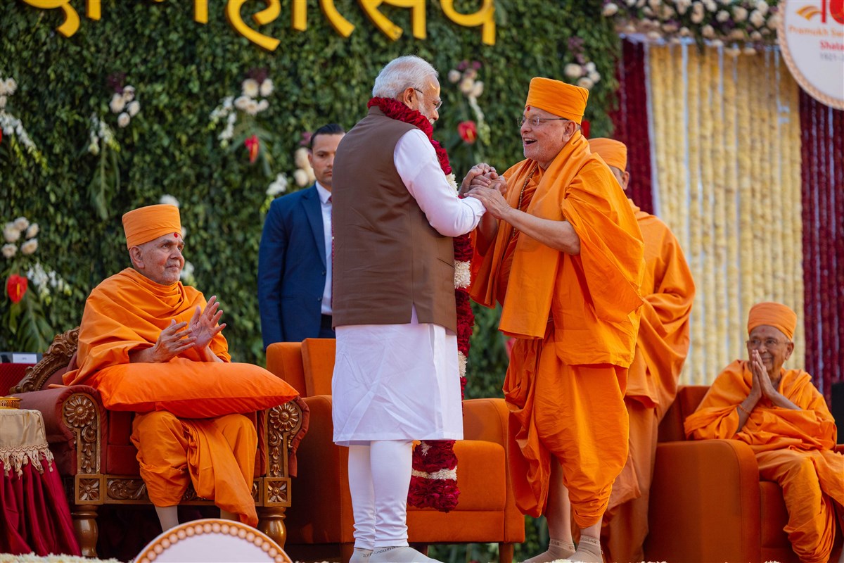 Pujya Ishwarcharan Swami welcomes PM Narendra Modi with a garland