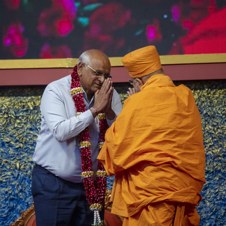 Pujya Ishwarcharan Swami honors Shri Bhupendrabhai Patel with a garland
