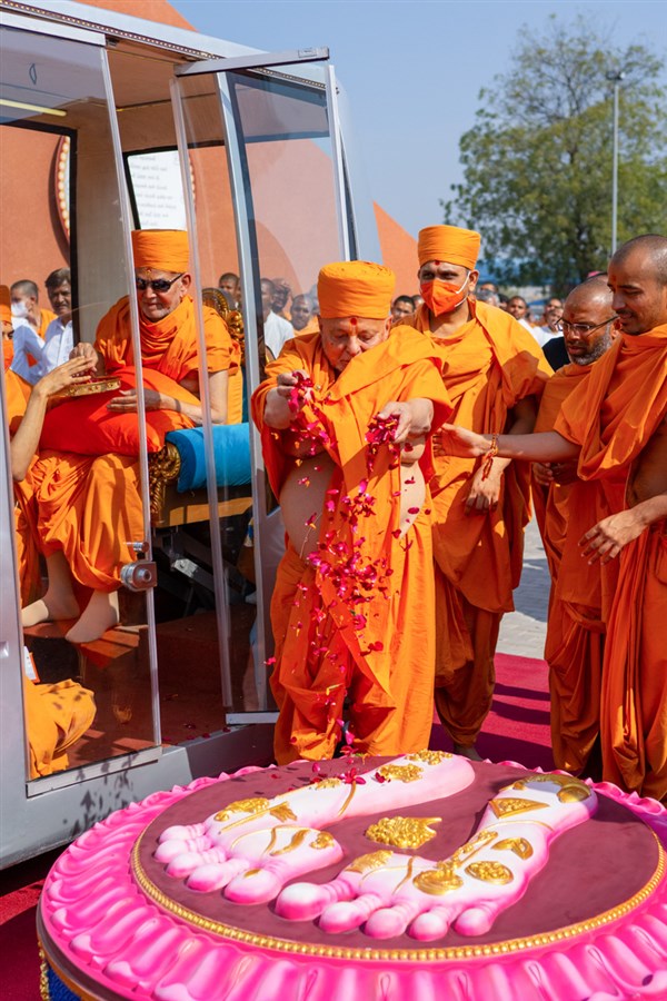 Pujya Ishwarcharan Swami showers flower petals on the holy charanarvind of Bhagwan Swaminarayan