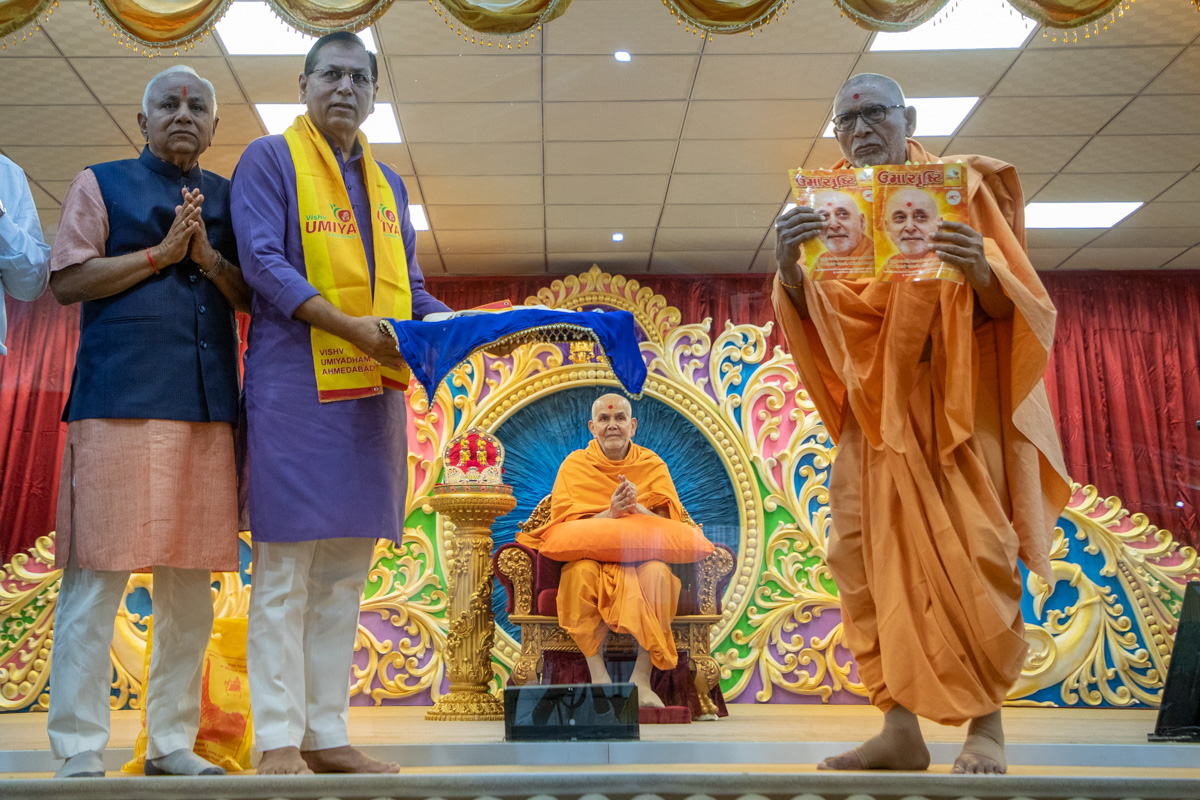 Pujya Bhaktipriya Swami (Kothari Swami) receives a special edition of the Umasrushti
