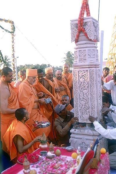  	Swamishri places the pillar himself by operating the crane consol