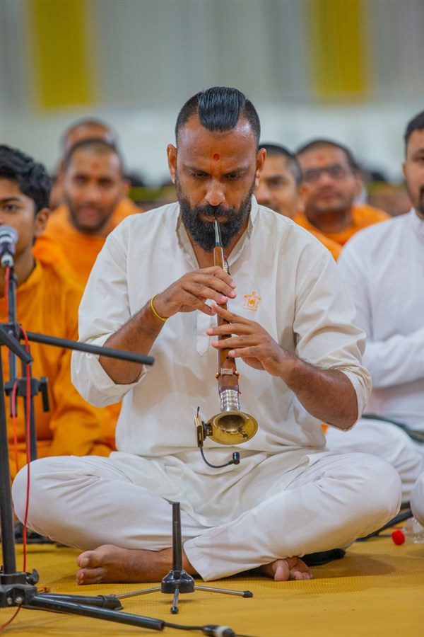 A youth plays a shehnai in Swamishri's daily puja
