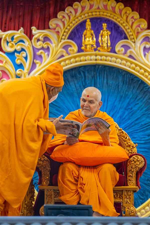 Swamishri observes the book