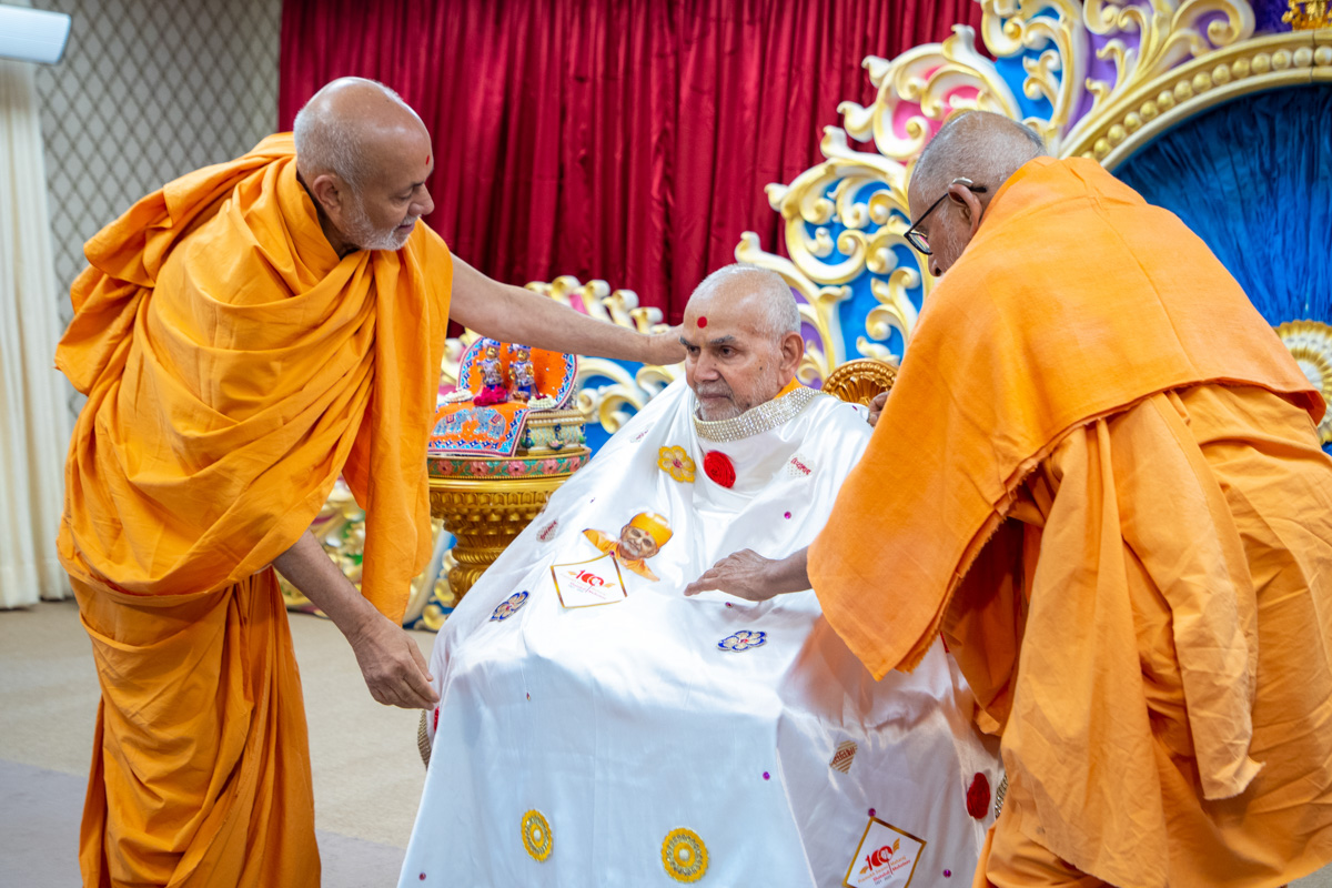 Pujya Kothari Swami and Pujya Viveksagar Swami honor Swamishri with a shawl