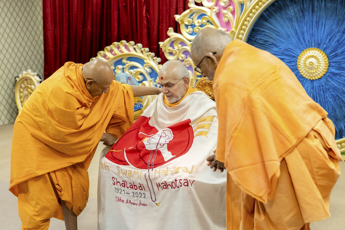 Pujya Kothari Swami and Pujya Tyagvallabh Swami honor Swamishri with a shawl