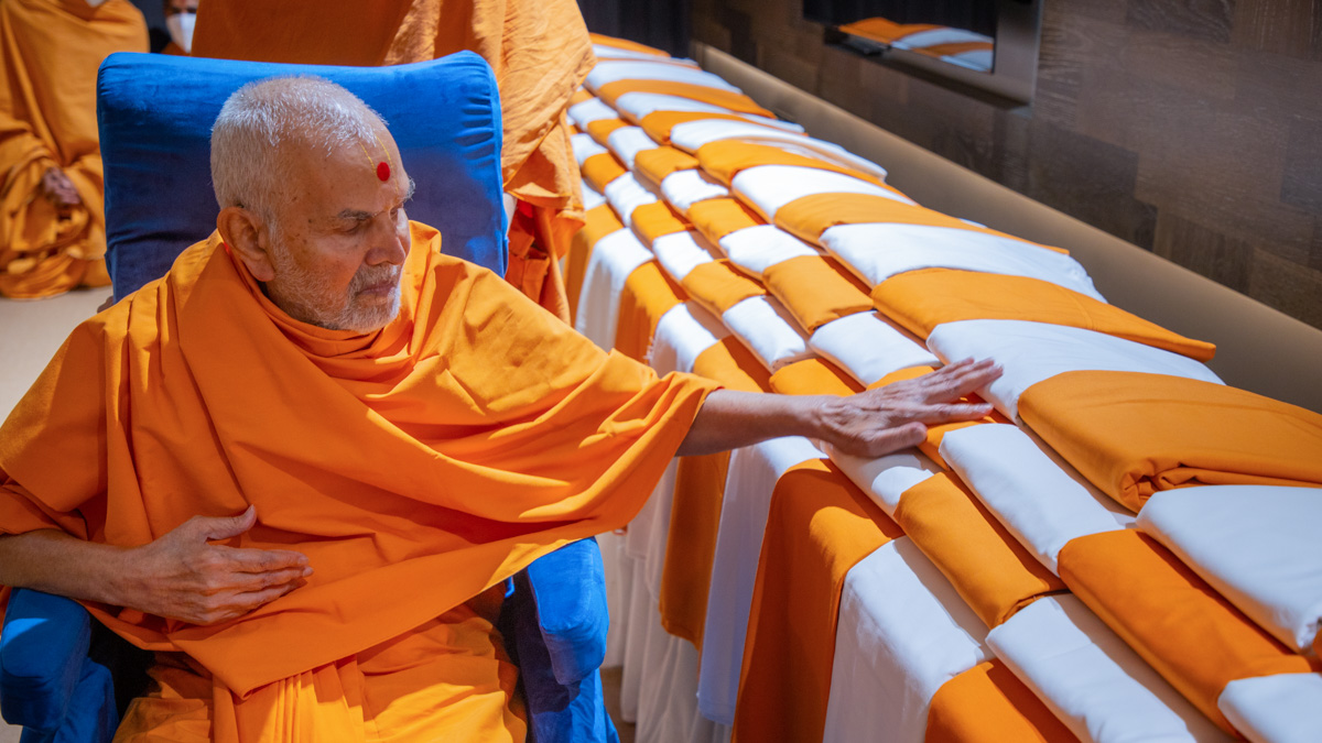 Swamishri sanctifies cloths for sadhus and parshads