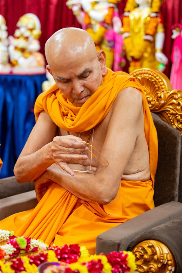 Param Pujya Mahant Swami Maharaj applies a tilak on his upper arm