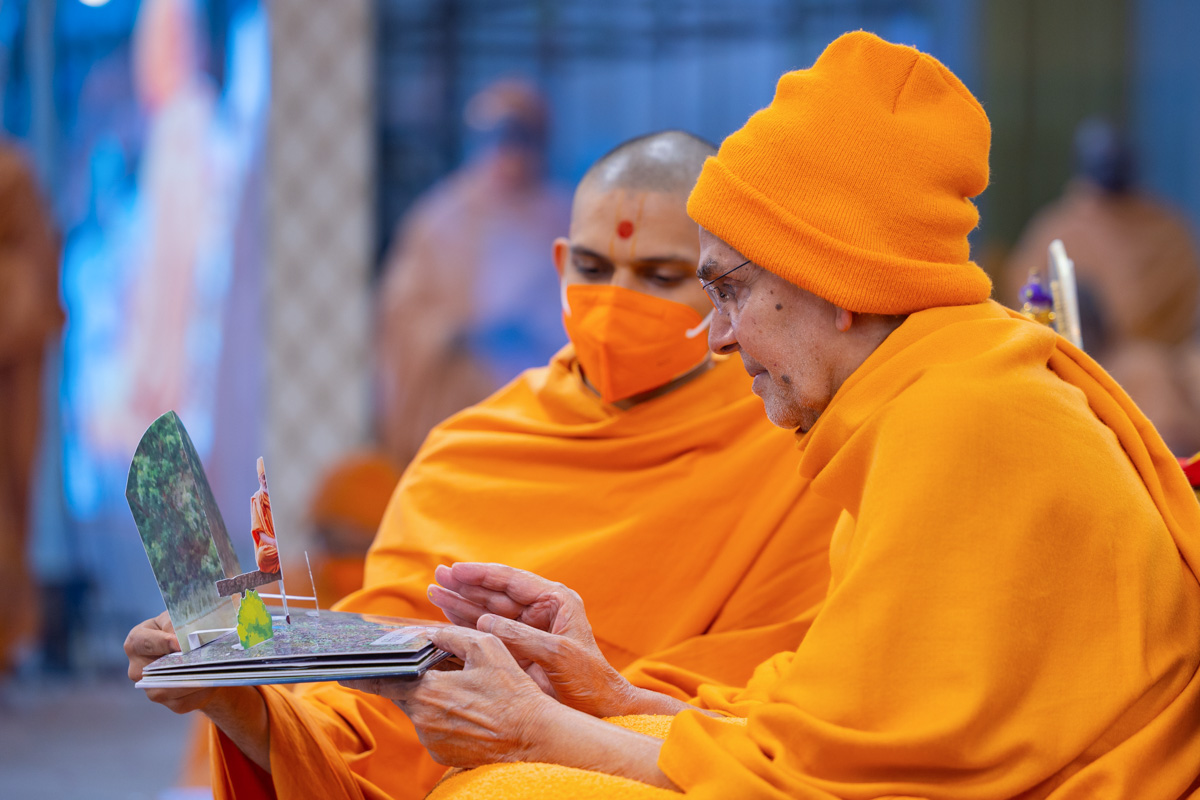 Swamishri observes an invitation card